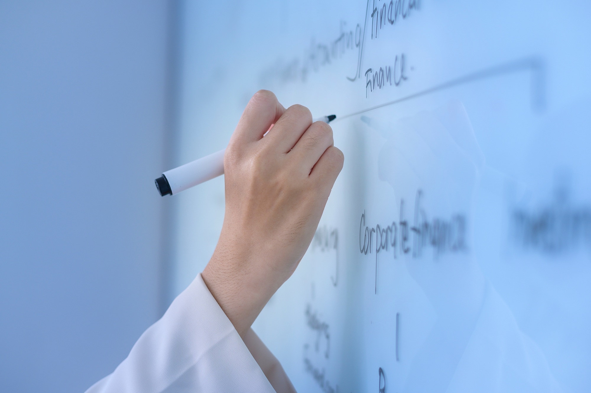 Human's hand writing on white board